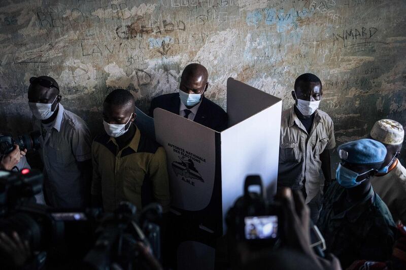 Central African Republic President Faustin Archange Touadera (centre), is seen at a voting booth surrounded by the presidential guard at the Barthélemy Boganda high school polling station in the 4th district in Bangui during the country's presidential and legislative elections. AFP