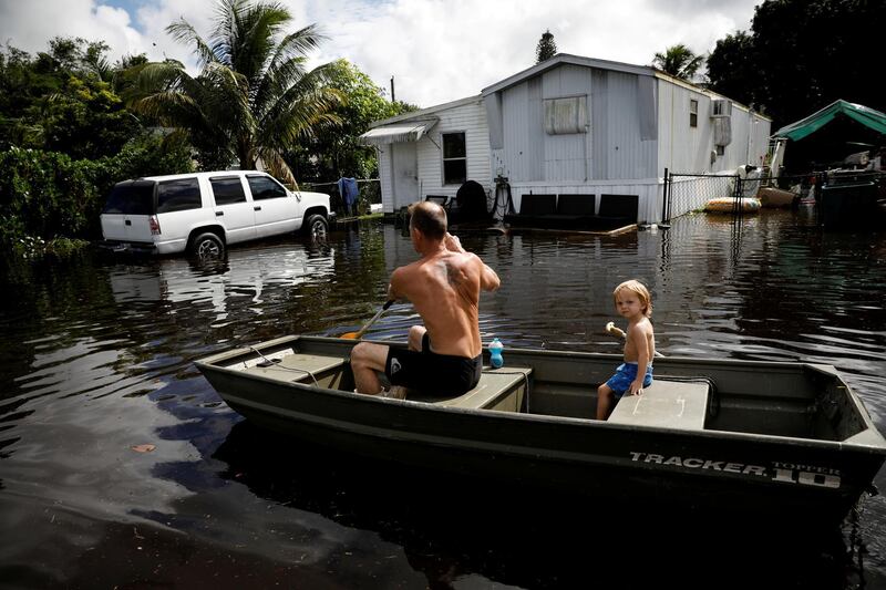 A man rows a boat in floodwaters caused by Tropical Storm Eta in Davie, Florida, U.S., November 9, 2020. REUTERS/Marco Bello REFILE - CORRECTING TO TROPICAL STORM