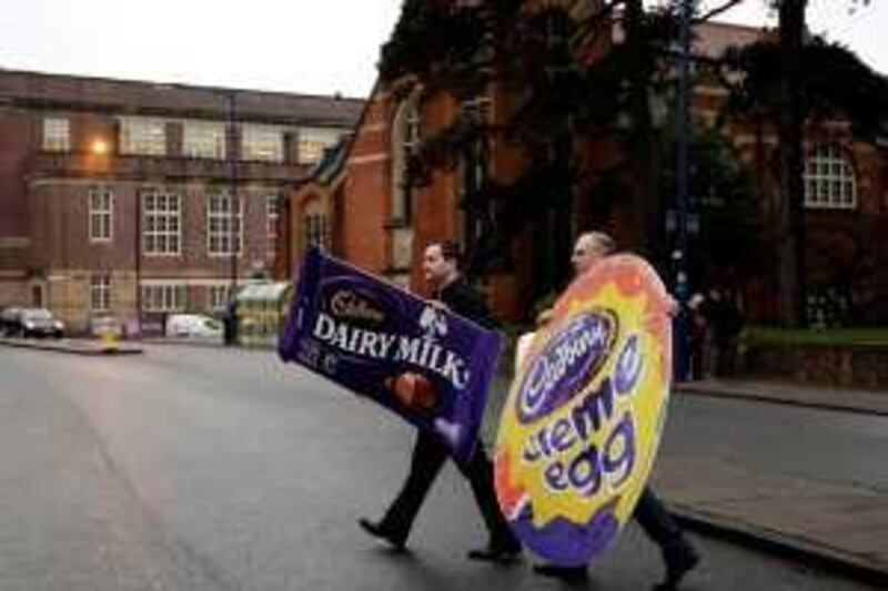 Workers cross a road to attend a union campaign launch at the Cadbury factory in Bournville, central England, December 15, 2009. The Unite Union and Cadbury workers today launched a campaign to protect their company's independence and fend off a hostile bid by Kraft. Kraft Foods has vowed to maintain discipline in its pursuit of British chocolatier Cadbury, suggesting the U.S. group will resist raising the price of its hostile bid.      REUTERS/Darren Staples (BRITAIN - Tags: BUSINESS FOOD) *** Local Caption ***  DST04_CADBURY-KRAFT_1215_11.JPG