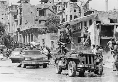 A French paratrooper officer atop a French military jeep (wearing sun glasses) and Palestinian fighters precedes the motorcade of Palestine Liberation Organisation (PLO) chairman Yasser Arafat shown in a picture dated 30 August 1982 in Beirut, surrounded by heavy security as he leaves Israeli-occupied Beirut for Tunis.  EDS NOTE: B/W only. (Photo by Dominique FAGET / AFP)
