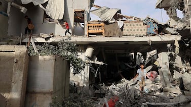 Palestinian youths search the rubble of a building hit in overnight Israeli bombardment, in Rafah. AFP