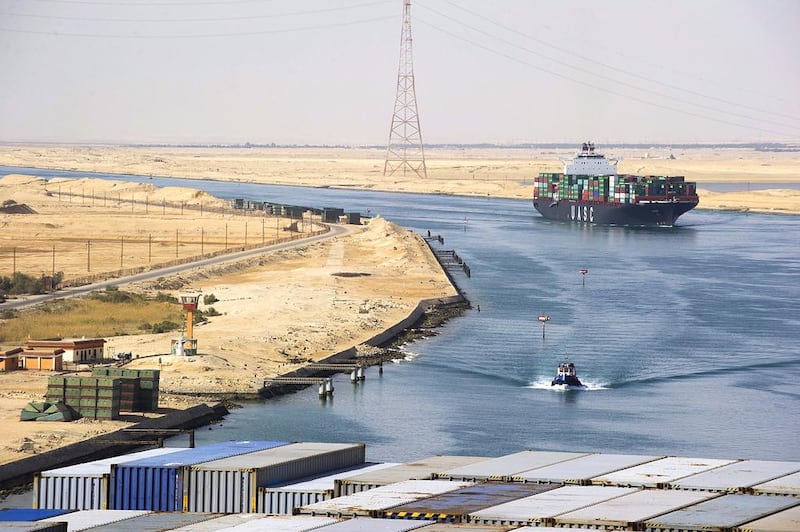 A Suez Canal Authority pilot vessel, centre, navigates a convoy of container ships as they pass southbound along the Suez Canal in Egypt. Kristian Helgesen / Bloomberg News
