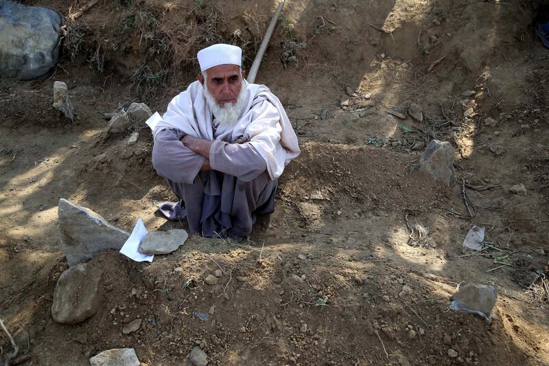 A man sits next to the grave of his relative who was killed in an explosion at a mosque in Haska Mena district of Nangarhar province, Afghanistan.  EPA