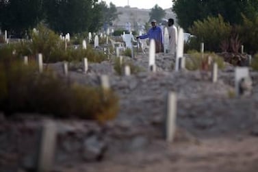 Relatives visit graves of their loved ones at the Bani Yas Cemetery. Now a new cemetery there has been designed for non-Muslims.