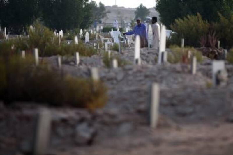 September 10, 2010/  Abu Dhabi /  Relatives visit graves of their loved ones on the first day of eid at the Bani Yas Cemetery September 10, 2010. (Sammy Dallal / The National)
