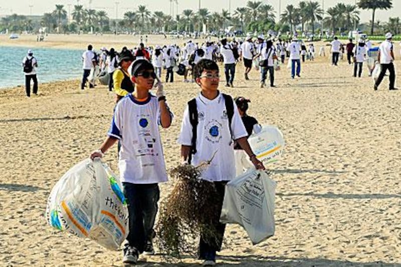 Members of the Filipino community help Dubai Municipality clean up Al Mamzar beach yesterday.