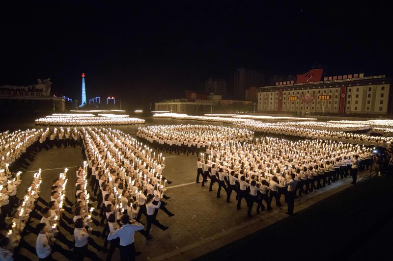 TOPSHOT - Participants perform in a torch parade on Kim Il Sung square in Pyongyang on September 10, 2018. - Thousands of North Koreans wielding burning torches and shouting slogans filled Kim Il Sung square in celebration of the country's 70th birthday. (Photo by Ed JONES / AFP)