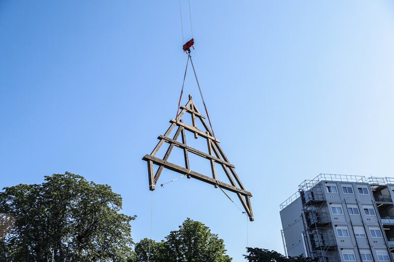 A wooden framework is transported with a crane to the construction site. EPA
