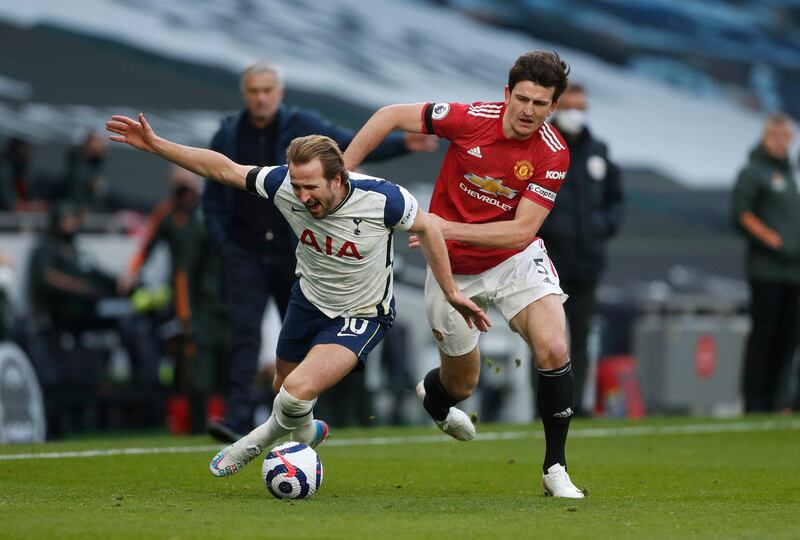 Spurs striker Harry Kane goes down under pressure from United defender Harry Maguire. PA