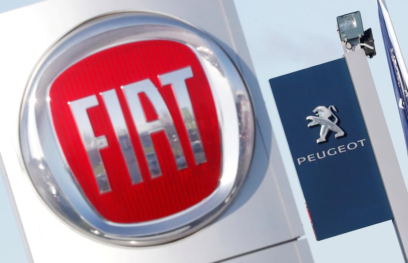 FILE PHOTO: The logos of car manufacturers Fiat and Peugeot are seen in front of dealerships of the companies in Saint-Nazaire, France, November 8, 2019. REUTERS/Stephane Mahe/File Photo