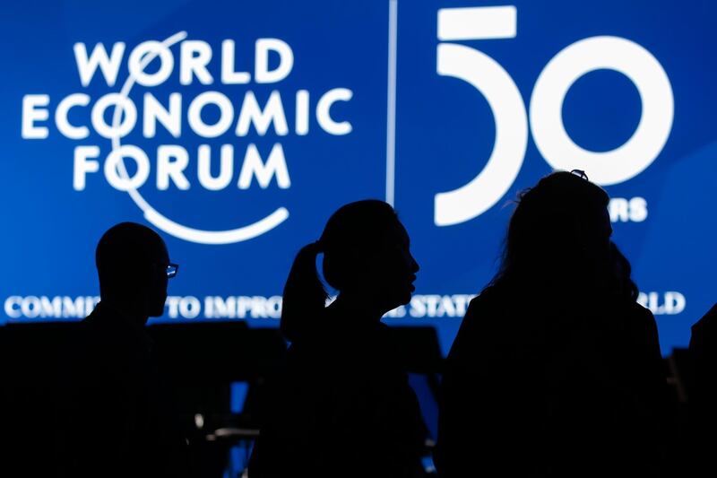 A screen silhouettes attendees at Davos. Bloomberg