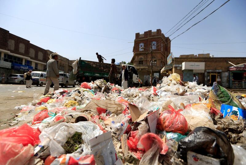 Yemeni workers collect rubbish piled up on the streets as garbage trucks hardly run due to an acute shortage of fuel in the capital Sanaa.  AFP