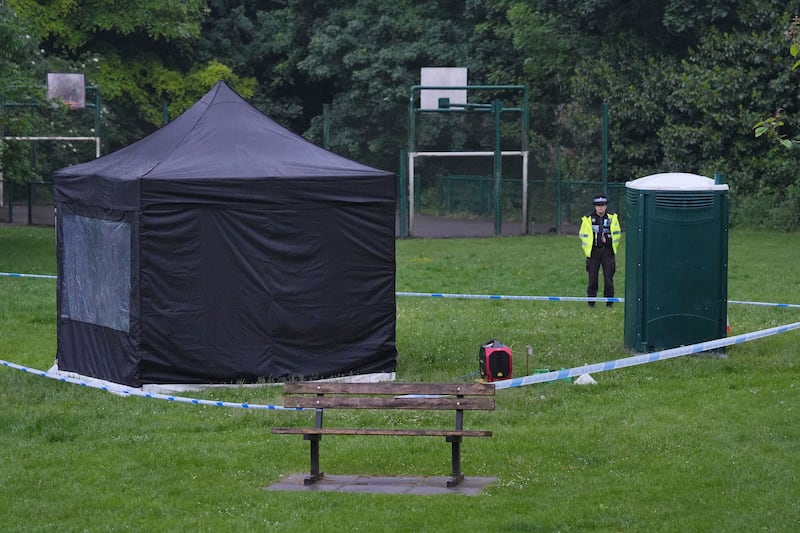 Police stand next to a black forensic tent in Grenfell Park, Maidenhead, where Mr Trickett's body was found. AP