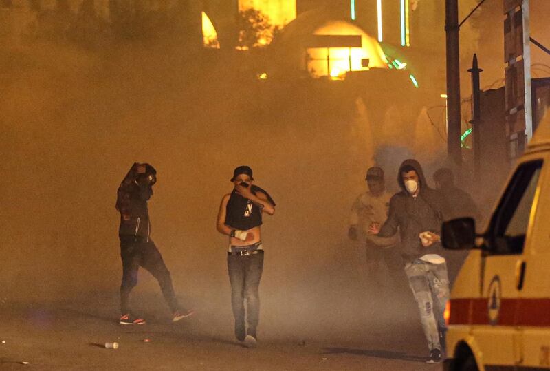 Protesters flee gas grenades after they threw stones at riot police during clashes in Beirut. EPA