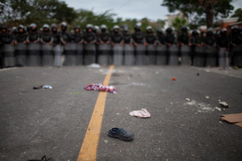 The shoe of a migrant lays on the highway where soldiers stopped a large group of Honduran migrants on their way to the US in Vado Hondo, Guatemala. AP Photo