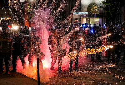 Fireworks go off in front of police, who with protesters in front of police headquarters in St. Louis on Monday, June 1, 2020. The small group of protesters was originally part of a much larger group demonstrating earlier in the afternoon against the death of George Floyd. (Colter Peterson/St. Louis Post-Dispatch via AP)