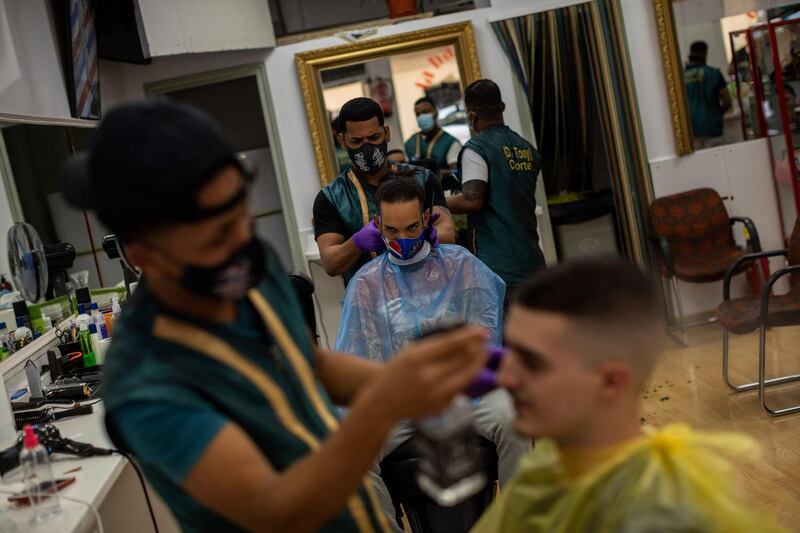 Customers get a haircut at a barbershop in the southern neighbourhood of Vallecas, Madrid, Spain. AP Photo