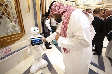 An attendee at the 2019 Future Investment Initiative in Riyadh last October finds out event information on a tablet carried by a robot. This year's event is set to attract more than 6,000 atendees from 110 countries. Bloomberg