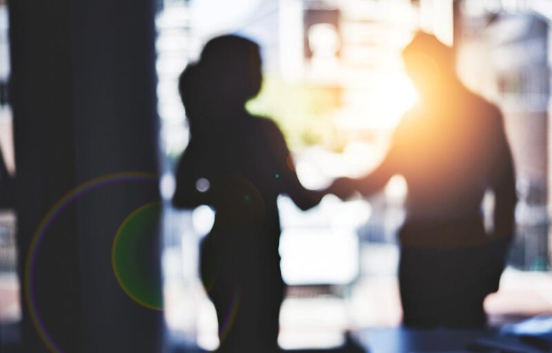 Defocused shot of two businesspeople shaking hands in an office