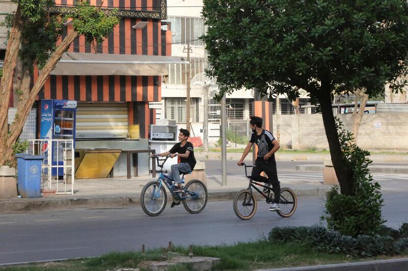 Iraqi youths ride their bicycles in the Karrada district of Iraq's capital Baghda, during a total curfew imposed by authorities to curb Covid-19 coronavirus cases. AFP