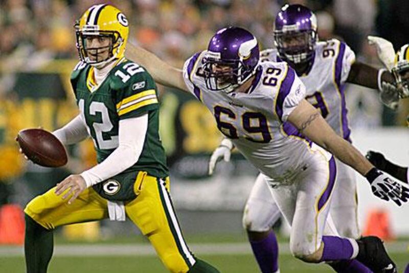 Even with Jared Allen, the Vikings defensive end, lurking, right, Aaron Rodgers produced another four touchdown game in Green Bay's 45-7 win.