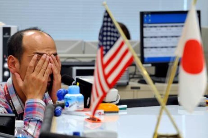 A money dealer covers his face with his hands at a Tokyo foreign exchange market on October 25, 2010. The US dollar hit a fresh 15-year low against Japanese yen in Tokyo trading as the greenback resumed its slide, amid continued expectations of more easing measures in the US.  TOPSHOTS    AFP PHOTO / Yoshikazu TSUNO

 *** Local Caption ***  496217-01-08.jpg