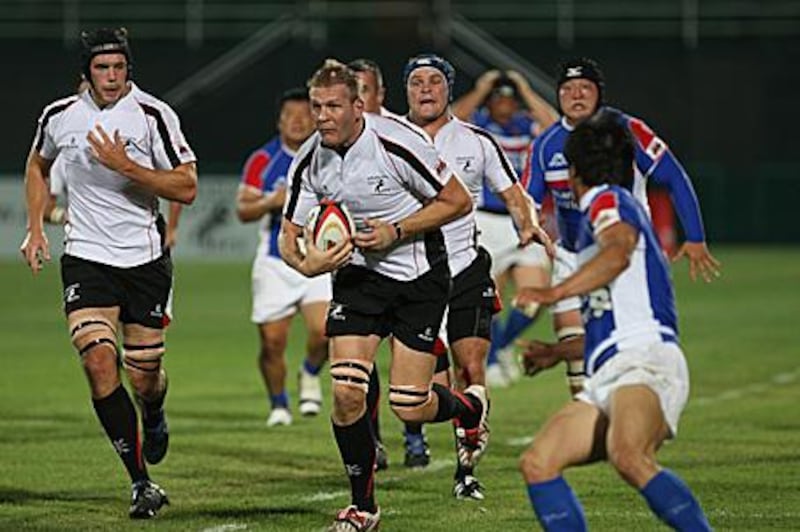 Michael Cox-Hill, centre, runs through the Korean defence during the Gulf's last ever match on Friday. Under the IRB's new laws, players can only represent their country of residence.