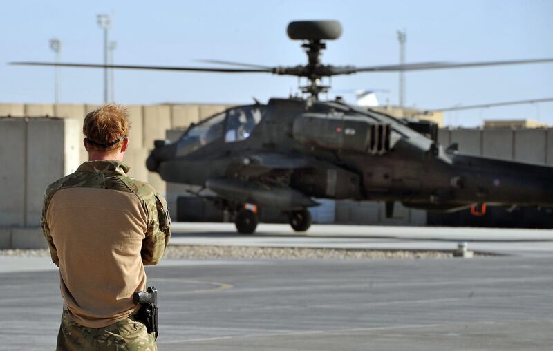 epa03549746 A picture dated 03 November 2012 shows Britain's Prince Harry or just plain Captain Wales as he is known in the British Army, watching the return from a mission, of an Apache Helicopter at the British controlled flight-line in Camp Bastion, southern Afghanistan, where he served as an Apache Helicopter Pilot/Gunner with 662 Sqd Army Air Corps, from September 2012 for four months until January 2013. Prince Harry ended his five-month deployment in Afghanistan on 21 January 2013 with an admission during a BBC interview that he shot at Taliban insurgents as a co-pilot gunner in an Apache attack helicopter. He remarked: 'Take a life to save a life'.  EPA/JOHN STILLWELL / PA WIRE / POOL UK AND IRELAND OUT *** Local Caption ***  03549746.jpg