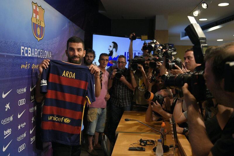 Arda Turan shows off his Barcelona shirt at his official presentation. Lluis Gene / AFP 

