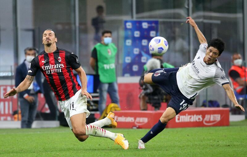 Zlatan Ibrahimovic is challenged by Bologna's Takehiro Tomiyasu. EPA