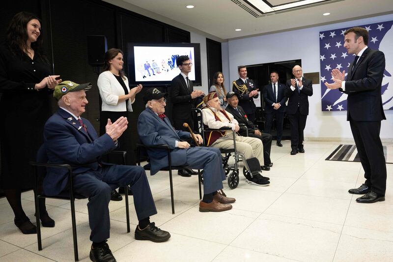 Mr Macron applauds Mr Davis, Carl Felton, Mr Idelson, Mr Portaro and Mr Reynolds after awarding them the Legion d'Honneur. AFP