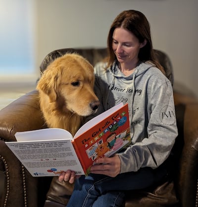 Kerry Nagle reading her childrens' book about leap year birthdays to her dog. Photo: Kerry Nagle