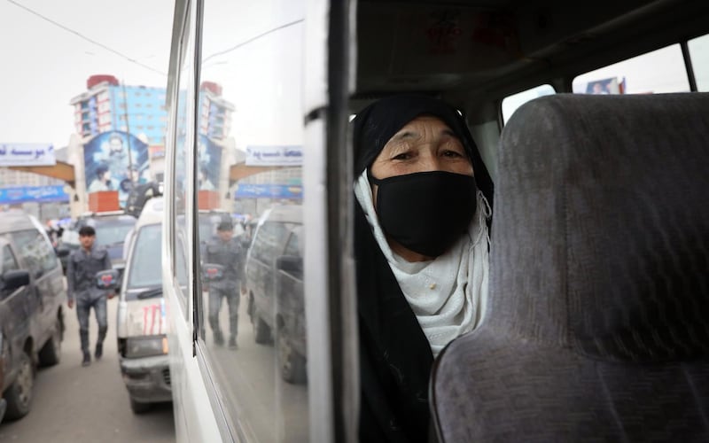 An Afghan woman wearing a face mask sitting in a bus in Kabul, Afghanistan, on March 23, 2020. EPA