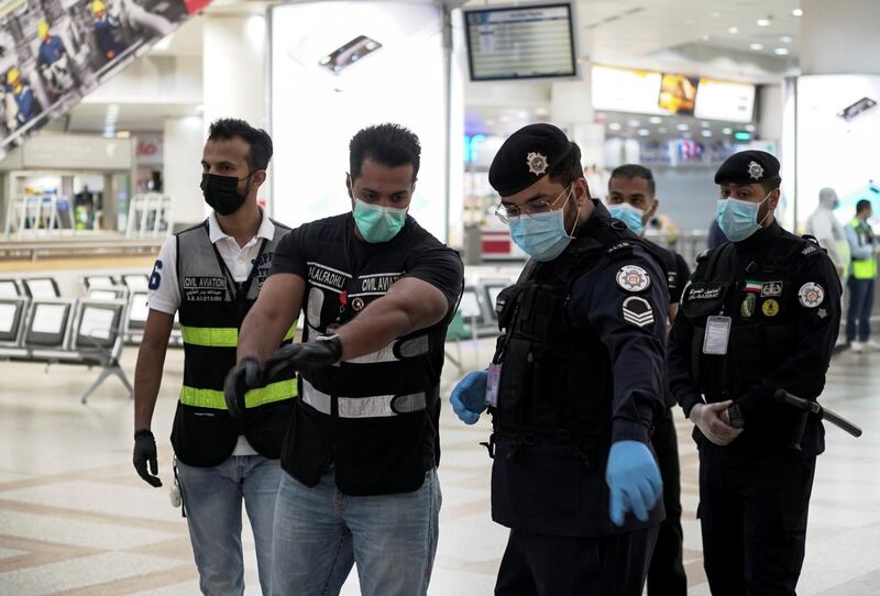 Police and civil aviation personnel wearing protective face masks work at the Kuwait Airport as the repatriation process of Kuwait citizens continues, following the outbreak of the coronavirus disease (COVID-19), in Kuwait City, Kuwait April 21, 2020. REUTERS/Stephanie McGehee