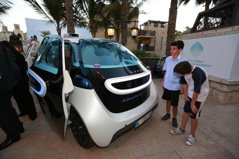 Students from the International School of arts and Science look at the LED lights of the Autonomous Smart Car. Victor Besa for The National.