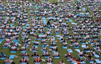 People practice yoga in Abu Dhabi on June 21, 2022. AP