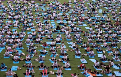 People practice yoga in Abu Dhabi on June 21, 2022. AP