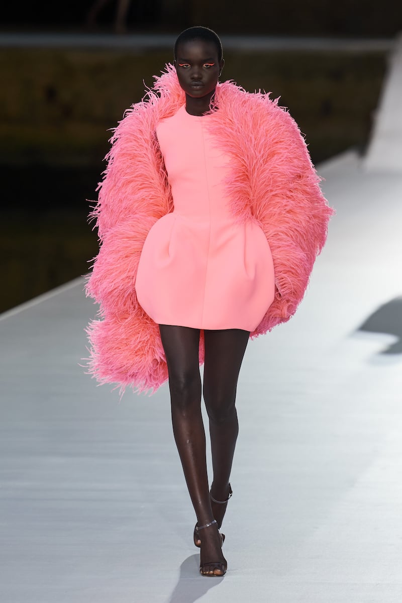 A puffball-skirted dress in flamingo pink is teamed with feathers of salmon pink at the Valentino autumn 2021 haute couture show