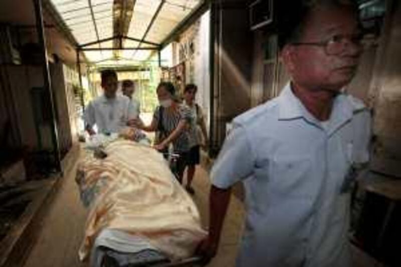 Thai patient on a stretcher is evacuated from Chulalongkorn Hospital on Friday, April 30. 2010. A major hospital is evacuating patients and suspending all but emergency surgery after anti-government protesters, who occupy a zone in central Bangkok adjacent to the facility, storm in to hunt for security forces they suspect are positioned there. (AP Photo/Sakchai Lalit) *** Local Caption ***  SL101_Thailand_Politics.jpg