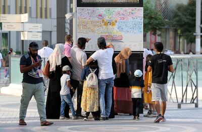 Visitors consult a map at Expo 2020 Dubai. Pawan Singh / The National. 