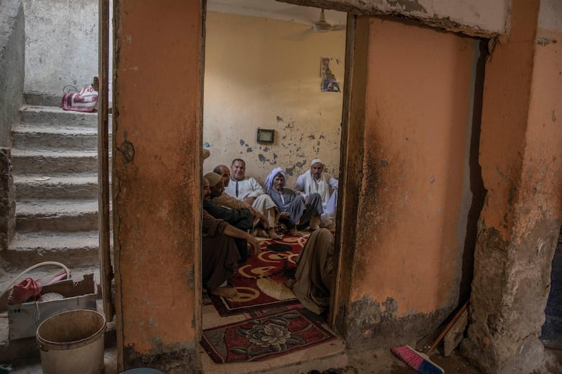 55-year-old Egyptian farmer Makhluf Abu Kassem sits with farmers in his home in Second Village, Qouta town, Fayoum. AP
