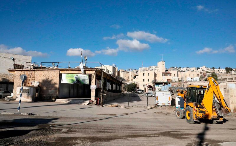 An excavator near old market building along al-Shuhada street in the flashpoint city of Hebron in the occupied West Bank. AFP