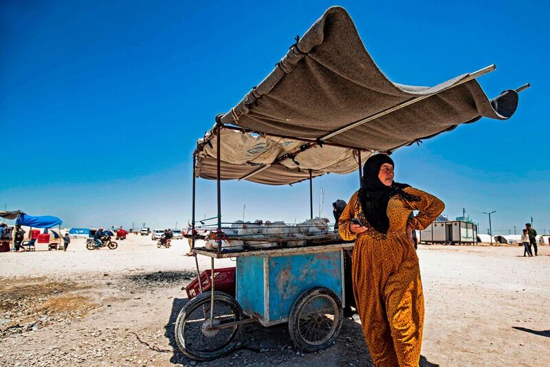 A displaced Syrian woman next to her cart, selling chicken, at the Washukanni camp for the internally displaced in Syria's northeastern Hasakeh province on May 10, during Ramadan. Delil Souleiman / AFP