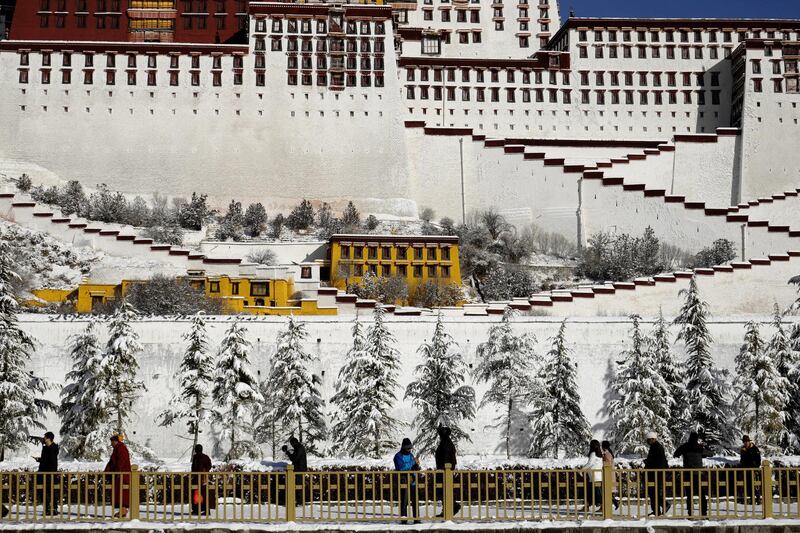 People walk past snow-covered trees outside the Potala Palace in Lhasa, Tibet Autonomous Region, China. Reuters