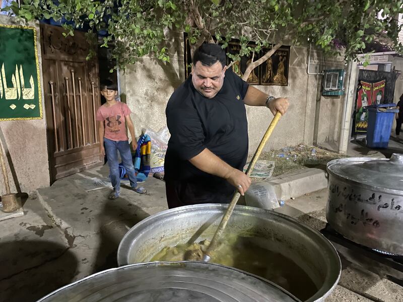Safa Jabbar Karim, 34, stirs a vat of meat. He says the community raised about 1.75 million Iraqi dinars ($1,200) for the food. Sinan Mahmoud / The National