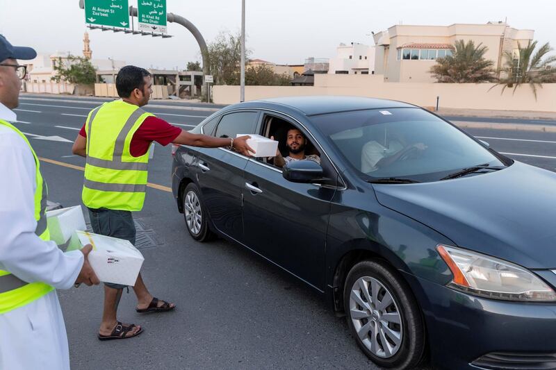 DUBAI, UNITED ARAB EMIRATES. 07 MAY 2019. Iftar meals being distributed to motorists by Marwan Al Hassan (wearing the baseball cap) and his team at the intersection of Al Asayel and 13D Str in Al Quoz 1. (Photo: Antonie Robertson/The National) Journalist: None. Section: National.