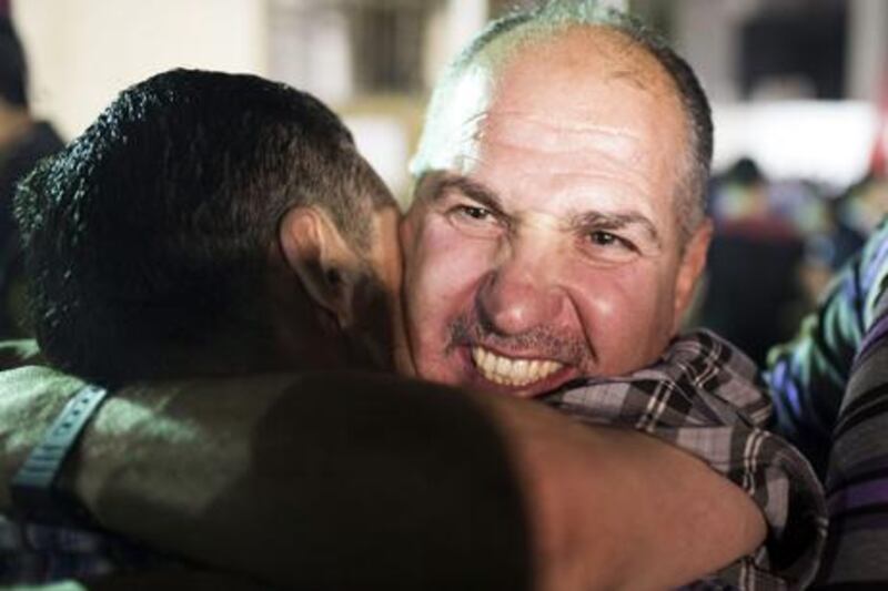 RAMALLAH, WEST BANK - AUGUST 14: A Palestinian prisoner released from an Israeli jail hugs his supporters in the Mikatah compound on August 14, 2013 in Ramallah, West Bank. Israel announced that 26 Palestinian prisoners will be released, 15 to Gaza and 11 sent to West Bank, as part of Israeli-Palestinian negotiations. (Photo by Ilia Yefimovich/Getty Images)