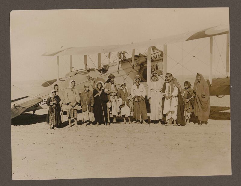 Iraq and Kurdistan - compiled by an RAF serviceman. A group portrait of several men and children pose in front of an airplane in Iraq, circa 1936-1938