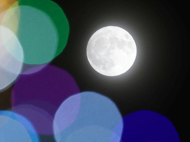 A full moon is seen through Christmas tree illuminations in Sapporo, northern Japan. Kyodo / via Reuters