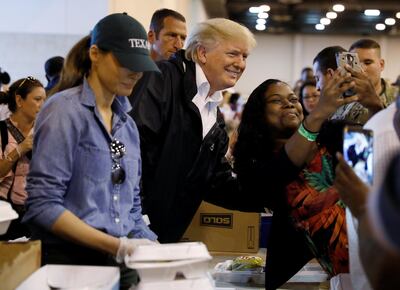 U.S. President Donald Trump poses for a photo as he and first lady Melania Trump help volunteers hand out meals during a visit with flood survivors of Hurricane Harvey at a relief center in Houston, Texas, U.S., September 2, 2017.   REUTERS/Kevin Lamarque